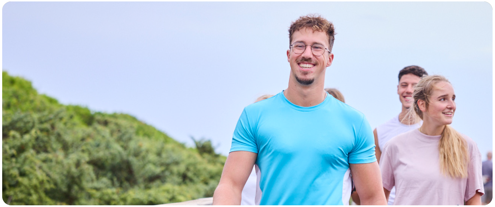 Animateur läuft mit Fitnessgruppe am Strand
